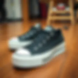 Black platform low top Converse shoes displayed on a wooden surface