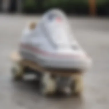 Close-up of all white Chuck Taylors on a skateboard deck