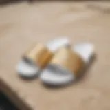 Stylish gold and white Nike slides showcased on a skate park ledge