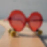 A close-up of red heart-shaped glasses resting on a skateboard deck, showcasing their vibrant color and unique design.