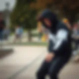 A skateboarder wearing a black and white zip-up hoodie performing a trick in a park.