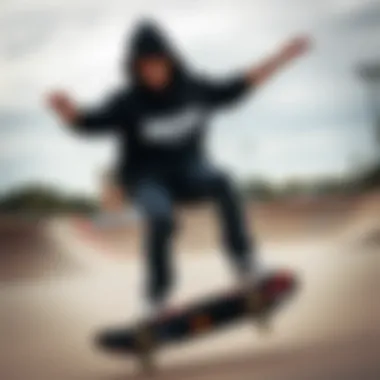 A skateboarder wearing the Hundreds black hoodie performing a trick at a skate park.